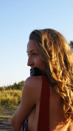 Beautiful young woman against clear sky