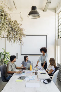 Smiling businesswoman planning with coworkers at office