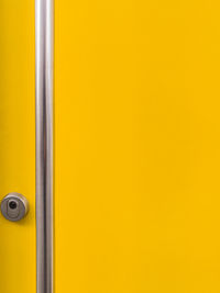 Close-up of handle on yellow door