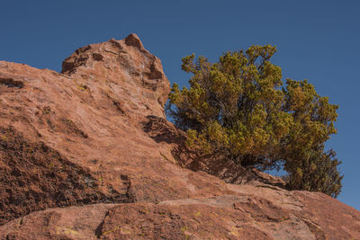 Low angle view of rock formation against clear blue sky