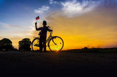 Boy holding american flag on landscape