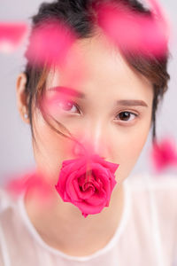 Close-up portrait of woman with pink rose