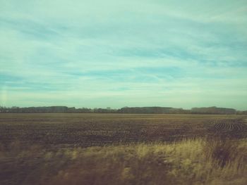 Scenic view of field against cloudy sky