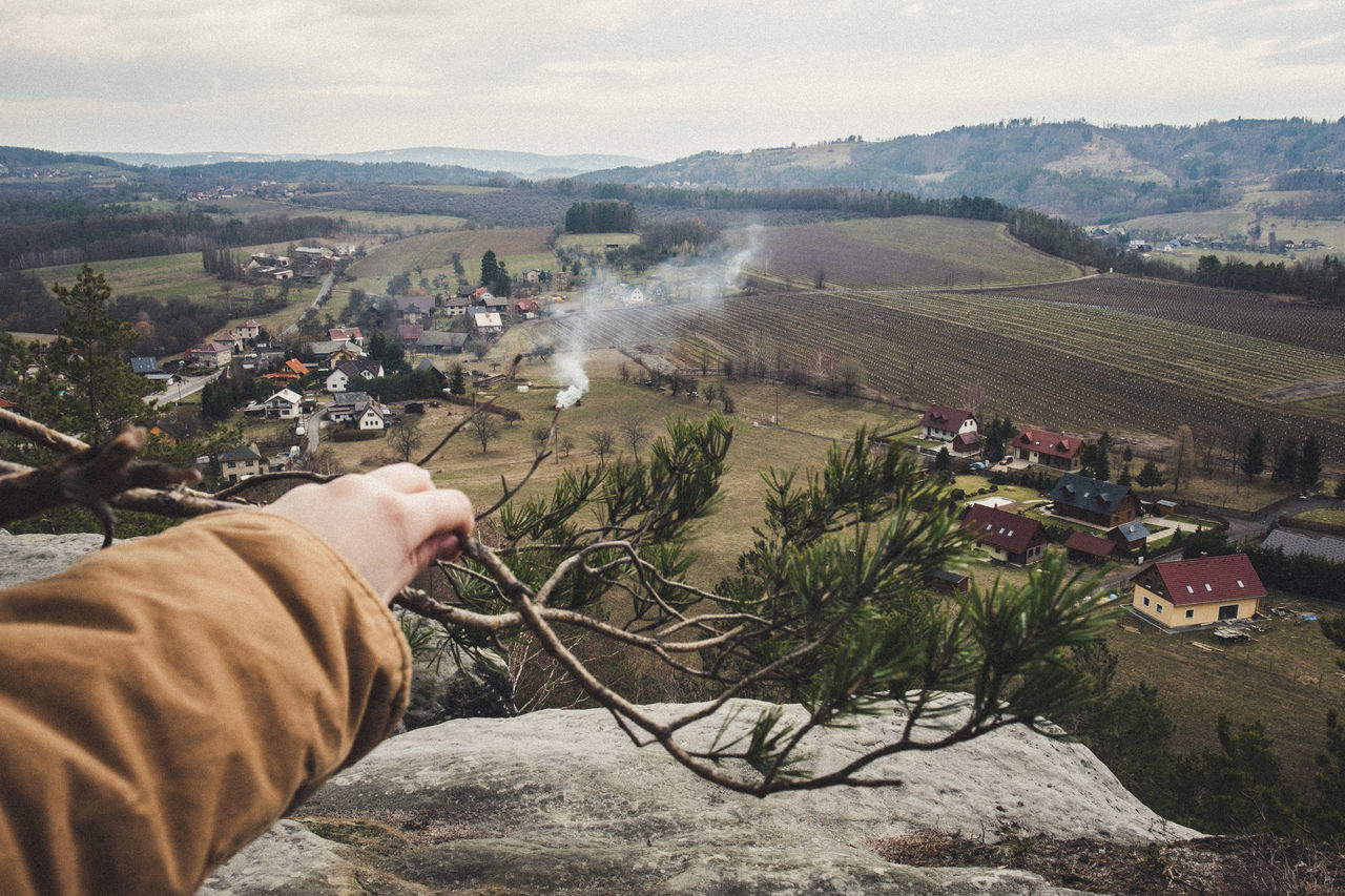 environment, mountain, architecture, nature, landscape, day, one person, human hand, built structure, scenics - nature, building exterior, sky, men, real people, outdoors, cloud - sky, mountain range, building, land, hand