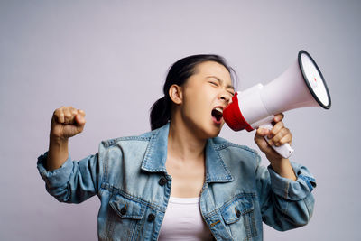 Full length of young woman standing against white background