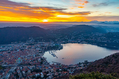 The city of como and the lake, photographed from brunate, at dusk, and mountains in the background.