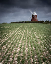 Traditional windmill on field against sky