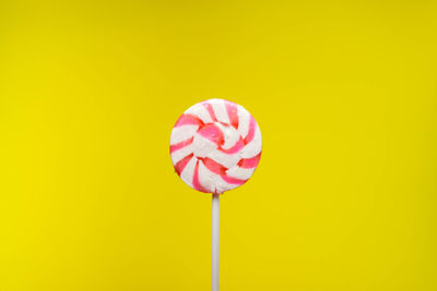 Close-up of pink umbrella against yellow background