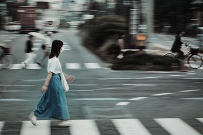 Blurred motion of woman walking on road