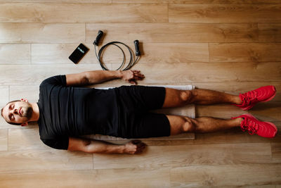 Man lying down on hardwood floor