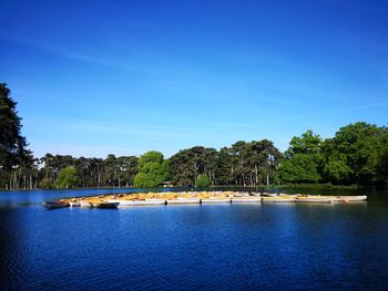 Scenic view of lake against clear blue sky