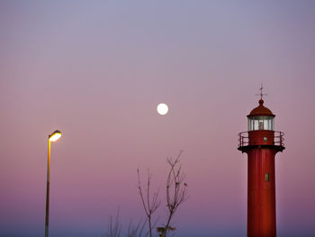 Low angle view of illuminated lighthouse against sky at night