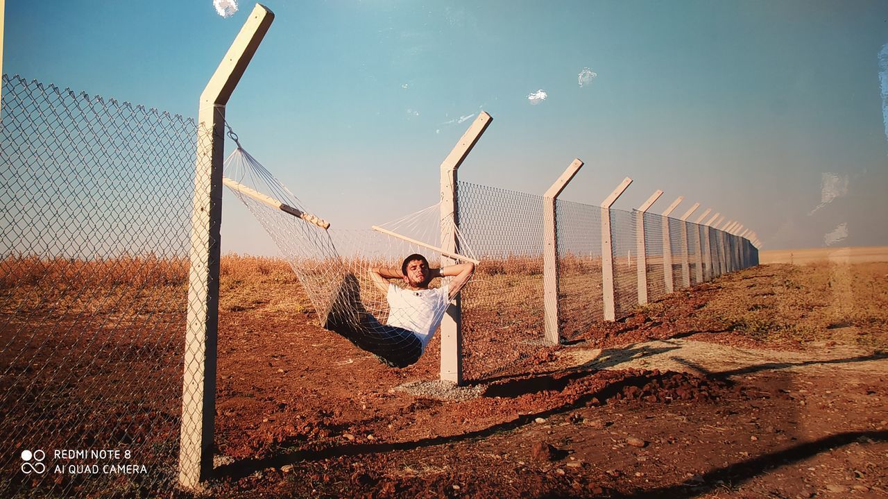 FULL LENGTH OF YOUNG WOMAN WITH ARMS RAISED