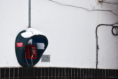 Telephone booth on wall during winter