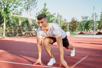 Side view of man exercising on field