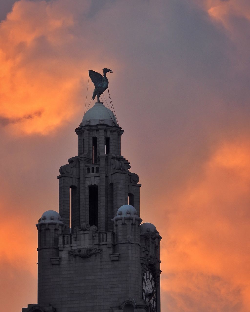 low angle view, sunset, architecture, built structure, orange color, sky, animal themes, cloud - sky, bird, flying, dome, travel destinations, history, famous place, outdoors, tourism, high section, no people, monument, sun, cloudy, architectural column, romantic sky