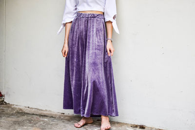 Midsection of woman standing against wall