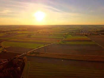 Scenic view of agricultural field against sky during sunset