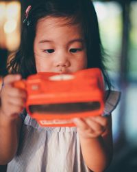 Close-up of girl holding red toy