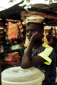 A street seller lost in thought during a short break from the day's hustle. 