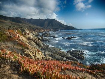 Scenic view of sea and mountains against sky