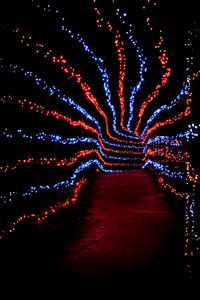 Low angle view of illuminated lights against sky at night