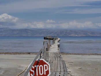 Information sign on beach against sky