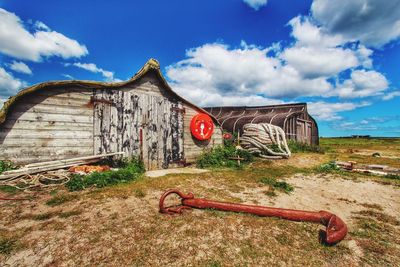 Abandoned building against cloudy sky