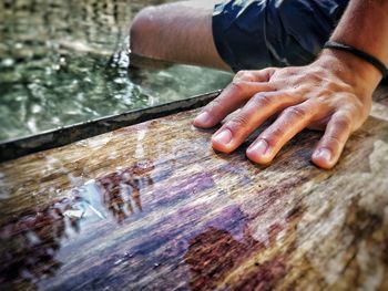 Close-up of hand holding wet wood