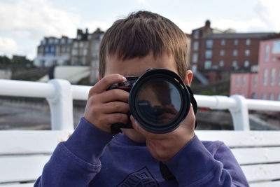 Portrait of boy holding camera