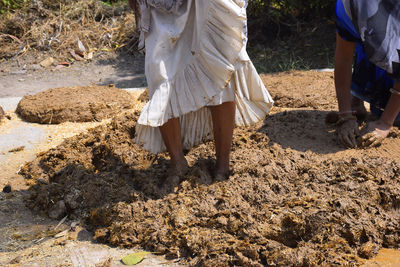 Low section of woman standing on mud land