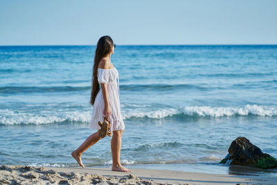 Rear view of woman standing on beach