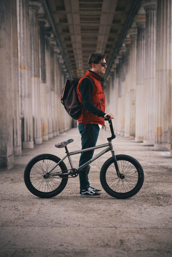 Man standing with bicycle in corridor