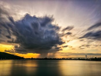 Scenic view of sea against cloudy sky during sunset