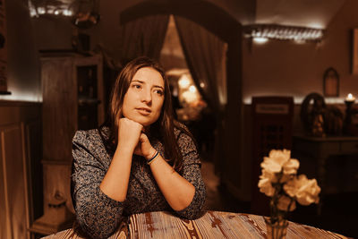 Emotions of lonely woman at cafe at the table drinking tea in the evening at cafe romantic light