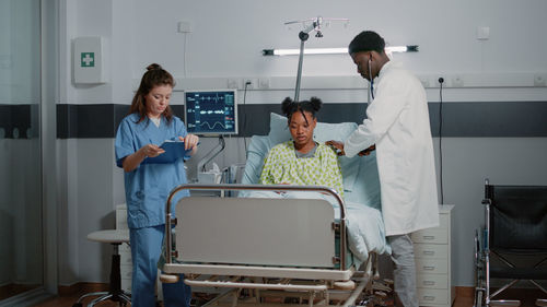 Midsection of doctor examining patient in clinic