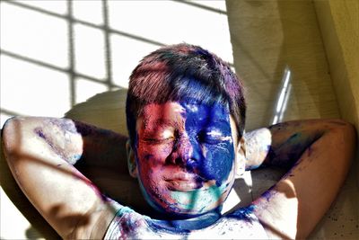 Close-up of eyes closed boy face with powder paints at home