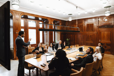 Team of lawyers discussing with businessman in board room during conference meeting