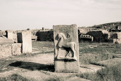 Stone cross in temple against sky