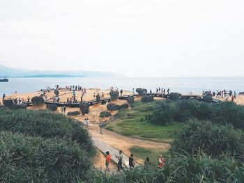 People on beach against clear sky