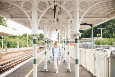 Full length of woman walking at railroad station platform