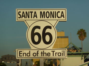 Close-up of road sign against sky