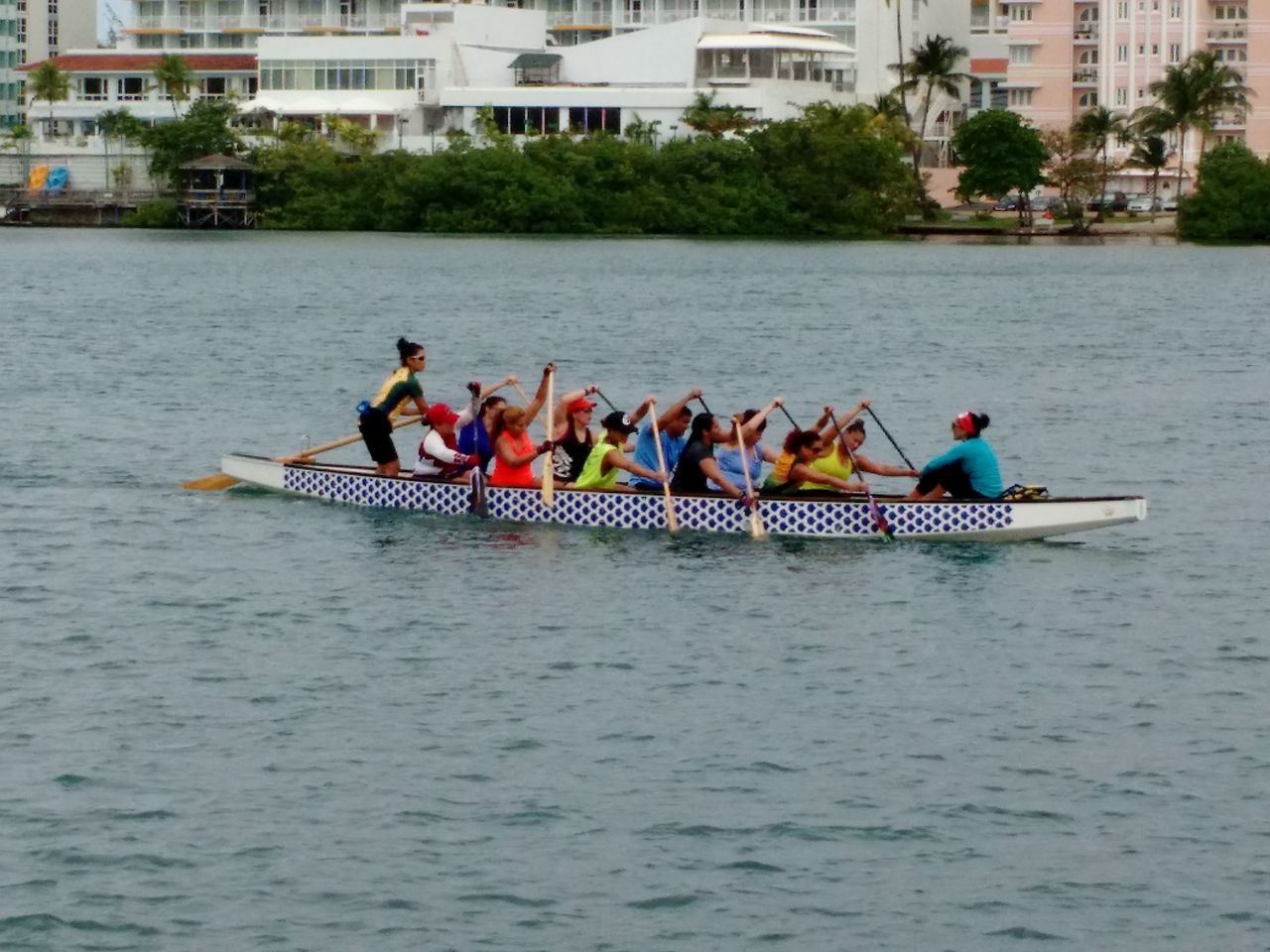 water, men, nautical vessel, lifestyles, transportation, leisure activity, waterfront, boat, mode of transport, large group of people, person, built structure, river, architecture, tourist, building exterior, medium group of people, vacations