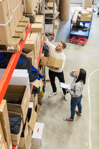 High angle view of colleagues examining boxes in industry
