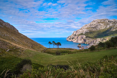 Scenic view of sea and mountains against sky