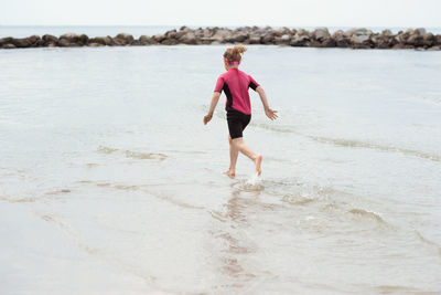 Full length of boy running on beach