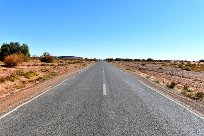 Road passing through landscape against clear sky