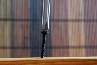 Close-up of screwdriver on wood