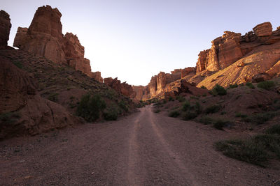 Road amidst rocks against clear sky