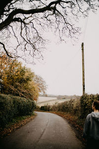 Rear view of woman walking on road